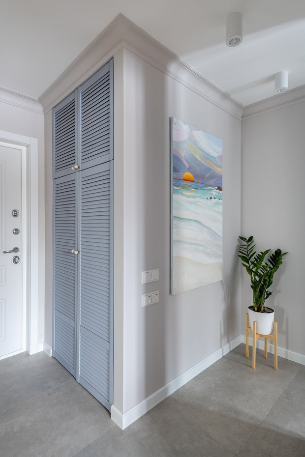 В прихожей встроенный шкаф под верхнюю одежду и сезонную обувь довольно бюджетный: сделали нишу и заказали жалюзийные дверки. Они выполнены из сосны и покрашены матовой краской Derufa.