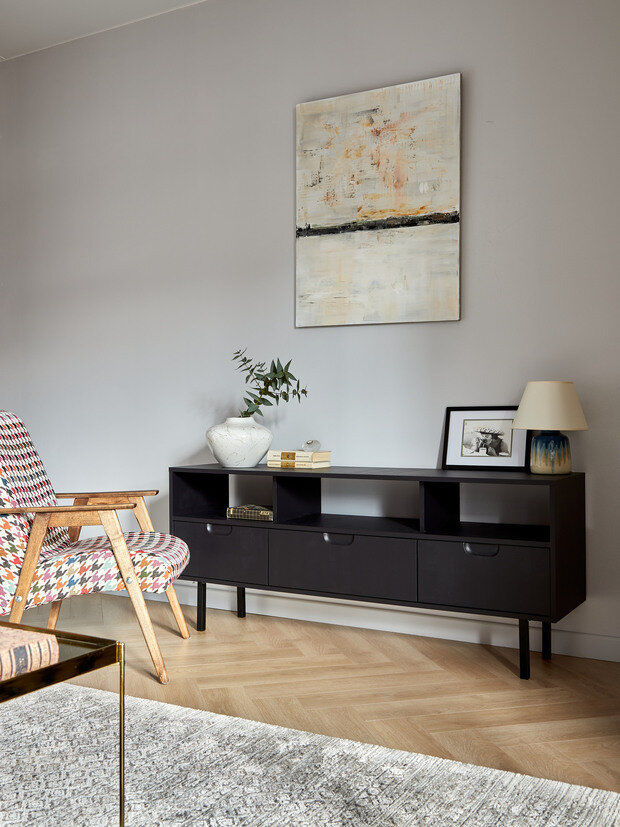 Черная тумба в гостиной была видоизменена руками дизайнера. Это обычная тумба с Авито, которую покрасили мебельной краской, добавили ножки и заменили ручки.