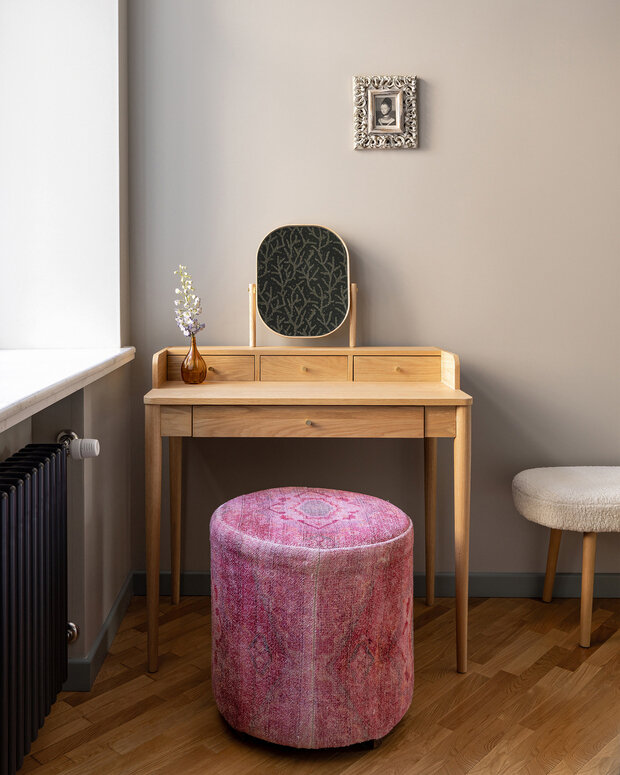 Интерьер кабинета в стиле джапанди с деревянным столом и розовым пуфом
