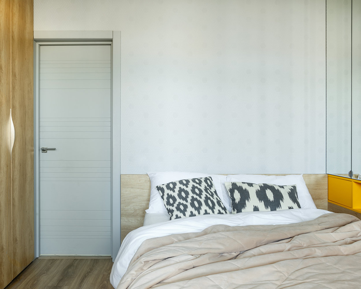 Основной материал стен — это моющаяся краска. В случае загрязнения ее легко отмыть. В спальне за изголовьем кровати применили обои с рельефным рисунком в форме гексагона (в поддержку плитке на полу и стенах санузла).