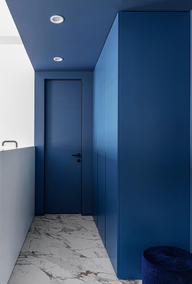 Прихожую визуально отделили от основного объема помещения, выделив ее с помощью сложного сине-голубого оттенка и керамогранита.