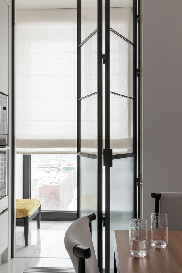 Дверь на лоджию заменили на стеклянную перегородку. Проем сделали уже, чтобы кухня идеально вписалась в нишу.