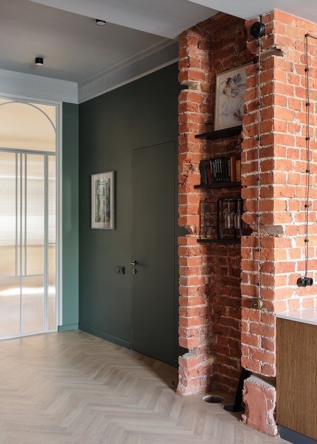 Ниша в кирпиче между кухней и прихожей осталась от предыдущих владельцев. Увы, они не пожалели несущую стену и устроили там вентиляцию. С незаконной вентиляцией расстались, нишу укрепили и устроили полки для книг, картин и декора.