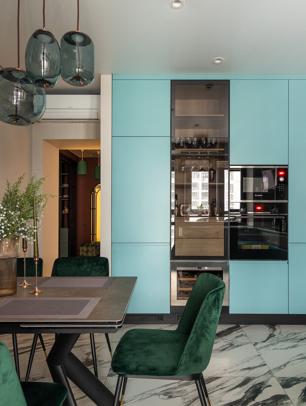 Интерьер кухни в современном стиле с бирюзовыми шкафами и мраморным полом