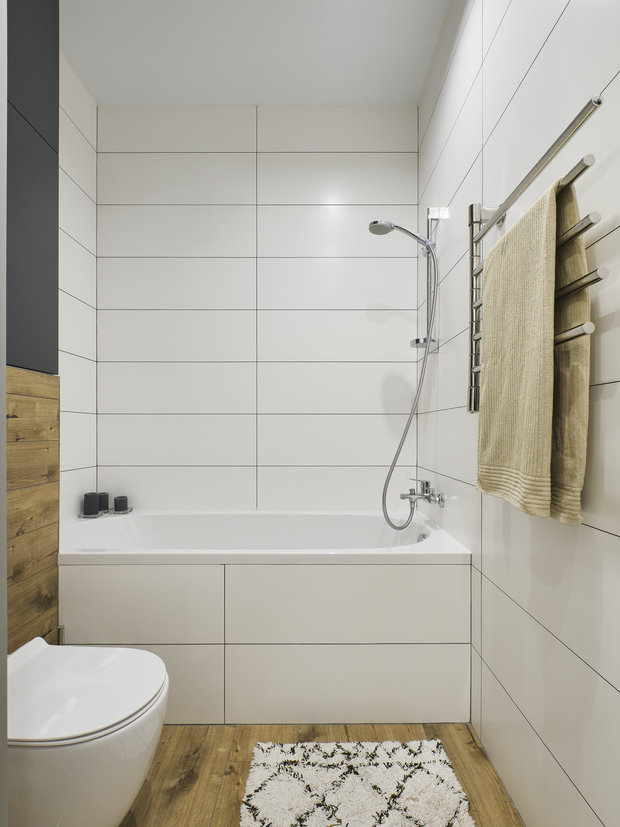 В санузле был сложный технический момент — линии коммуникации проходили прямо по центру длинной стены. Рядом с ними поставили инсталляцию унитаза, а над ней до самого потолка шкаф из МДФ. В этом шкафу спрятаны все трубы, счетчики и вентили.