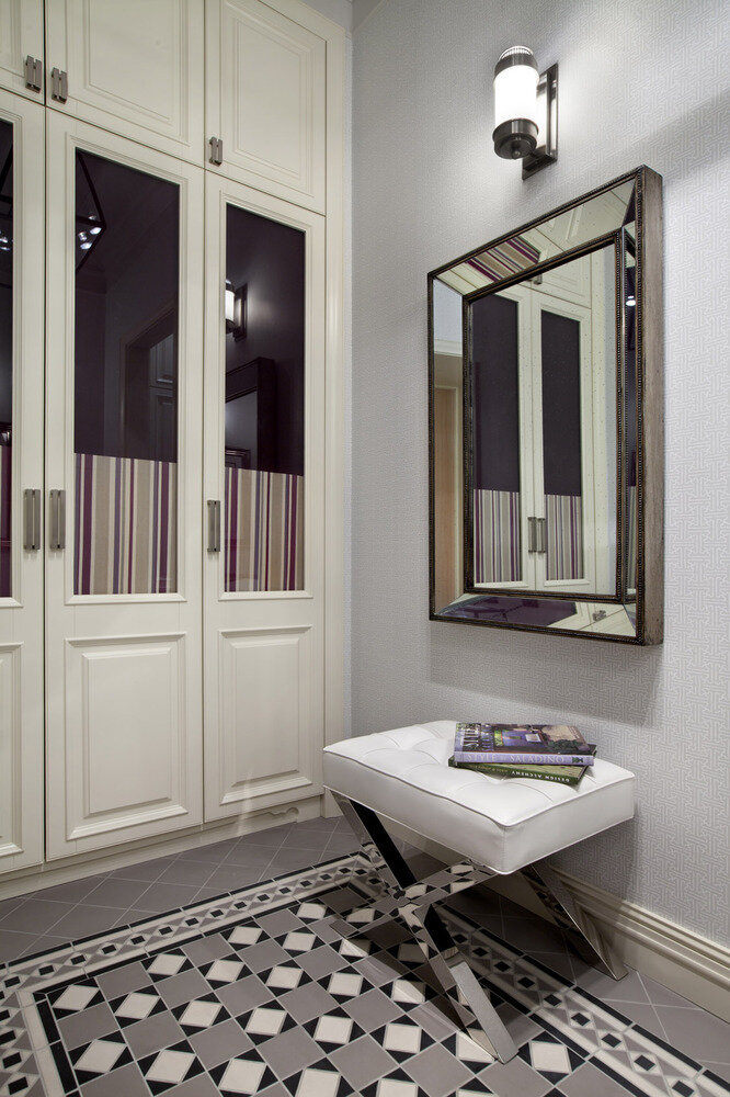 В прихожей внутри шкафов со стеклянными дверцами закреплены цветные шторки — они закрывают вид на куртки и плащи, но не только. «Дело в том, что из прихожей просматривается часть кухни. За счет текстильных вставок в шкафу мы поддержали ее сиреневую гамму», — рассказывает дизайнер.