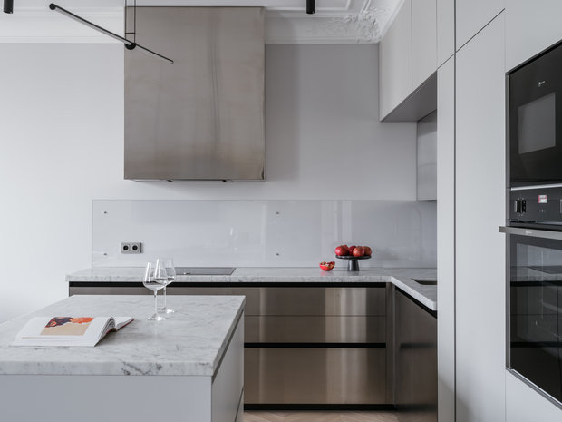 Интересным элементом кухни являются фасады из нержавеющей стали, которые дополняют серую гамму квартиры. У заказчика особое трепетное отношение к этому материалу.