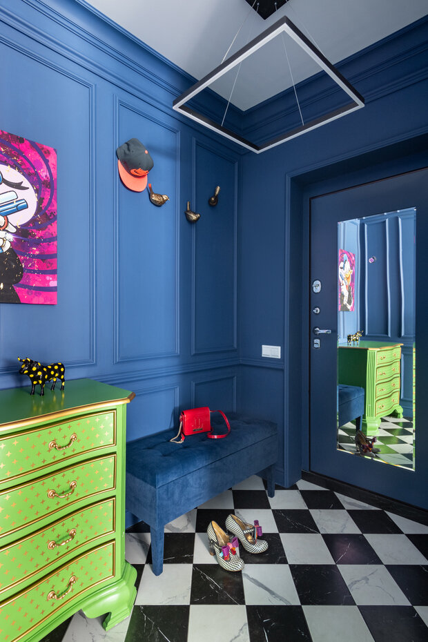 Прихожая получилась в духе Алисы в стране чудес. Черно-белый пол на контрасте с синими как бы классическими стенами с молдингами.
