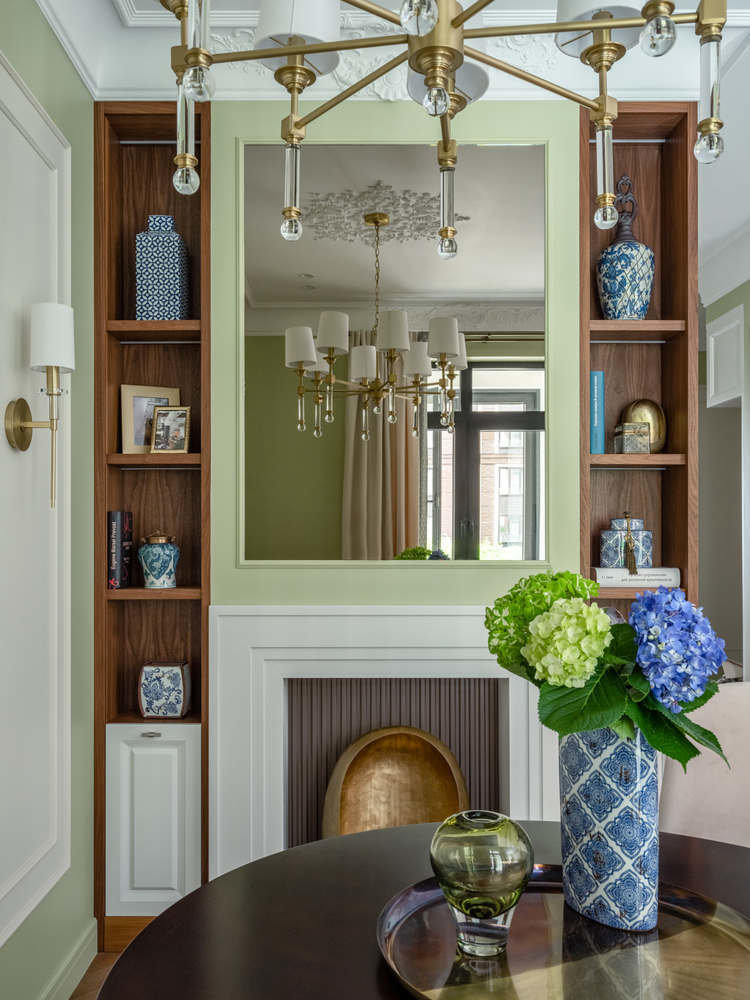 Столовую украшает конструкция из открытых полок и портала фальш-камина. Внутренняя часть портала — декоративные рейки в кофейном оттенке.