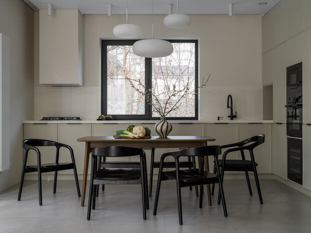 Дизайнер объединила стол в цвете темный орех и деревянные стулья в черной тонировке.