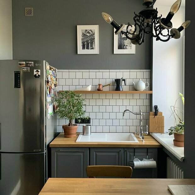 Интерьер кухни в современном стиле с темными шкафами и деревянной столешницей