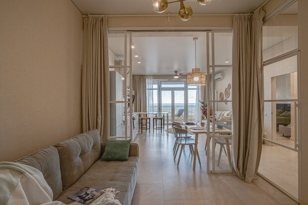 Фишкой и неотъемлемым дополнением стали плотные шторы, позволяющие создать в комнате приватность. Боковая дверь из коридора придает функциональности всей конструкции. Кстати, поглощение шума данной системы получилось достаточно высоким, несмотря на материал конструкции.