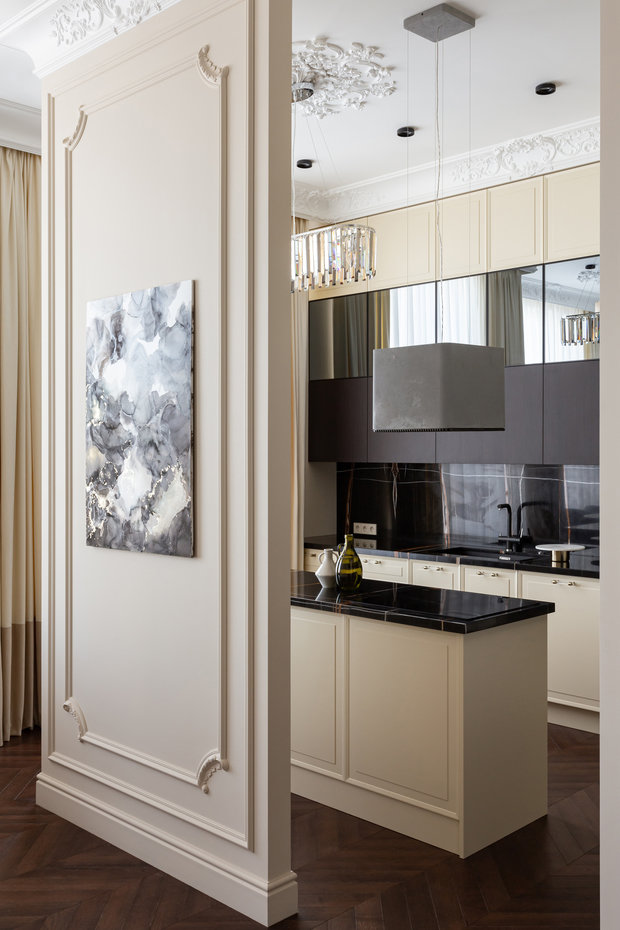 Мечта заказчицы — кухня с островом, ее отделили от гостиной стеной с проходами. Так как заказчики любят смотреть ТВ, их необходимо было разместить и со стороны кухни, и со стороны гостиной. 