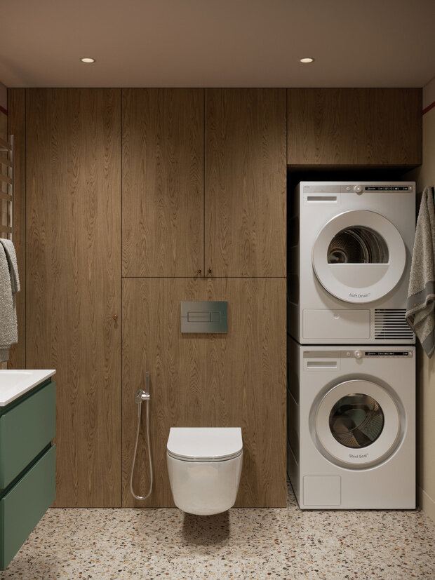 Чтобы не избежать ощущения заплаток, в зоне с инсталляцией решили использовать панели с текстурой дерева, а не плитку. Колонну с сушильной и стиральной машинами оставили бе фасада, чтобы обеспечить проветривание во время работы приборов.