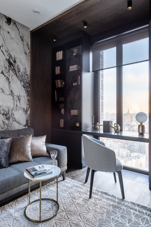 Отдельное украшение — это вид из окна! Стол, а точнее, столешницу, сделали у окна, в ней есть вырезы для прохождения теплого воздуха. Стеллажи для книг с затемненным стеклом, в нижней части предусмотрены розетки для принтера.