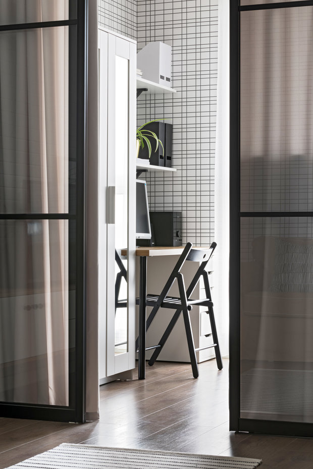 В спальне разместились гардеробный шкаф для одежды клиентов, также рабочая зона с полками для хранения.