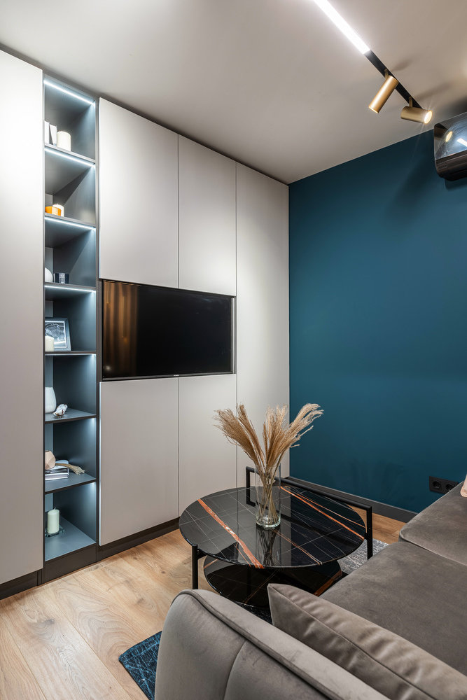 Перед диваном поставили крупный журнальный столик с фактурой натурального камня.