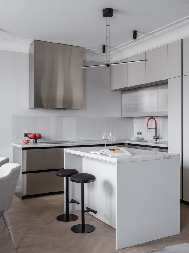 На кухне крупную лепнину на потолке поддержали легкими минималистичными люстрами Flos, которые практический тают в воздухе. 