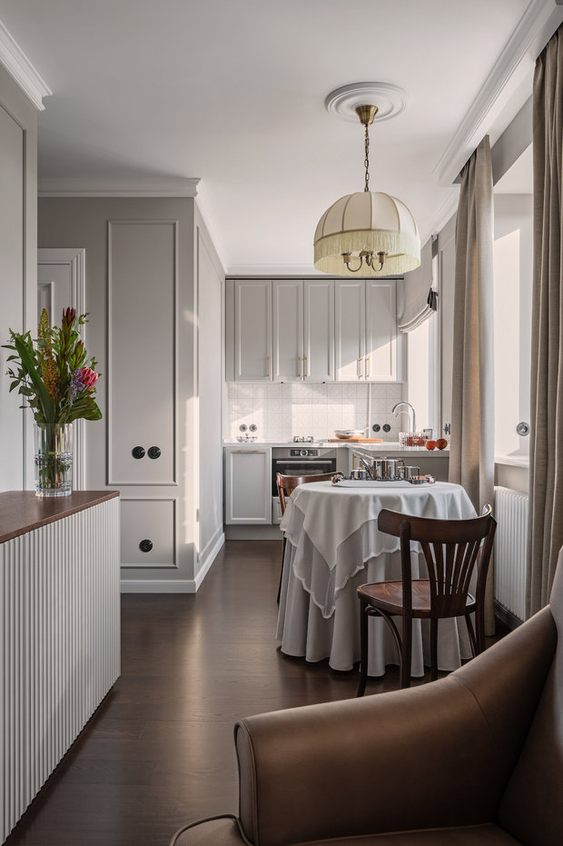 На кухне есть только самое необходимое: плита на две конфорки, компактный духовой шкаф с функцией микроволновки, вытяжка и спрятанные под столешницей холодильник и морозилка. В секции под мойкой установлен фильтр для воды, а остальное пространство отдано под хранение.