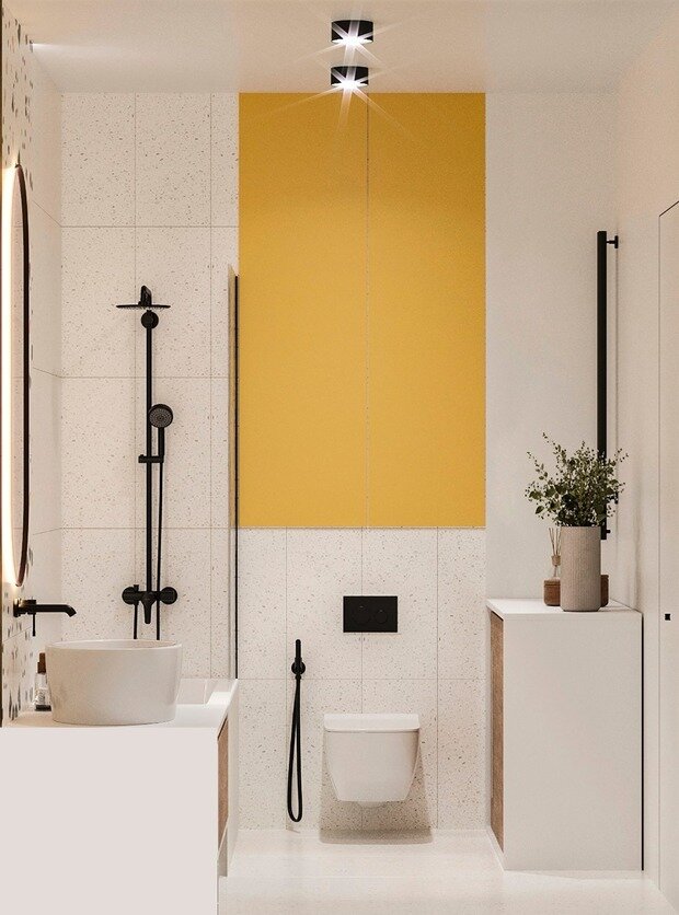 Керамогранит под терраццо с желтыми вкраплениями интересно поддерживает желтый шкафчик над инсталляцией.