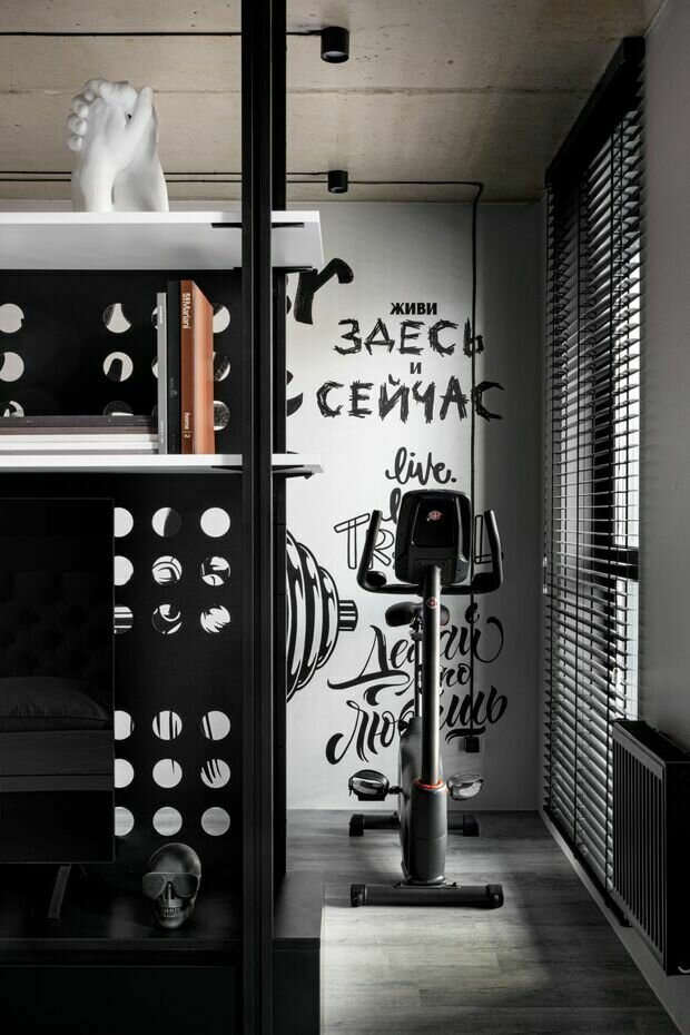 Стеллаж в спальне также выполняет функцию перегородки между зоной отдыха и спортивным уголком.