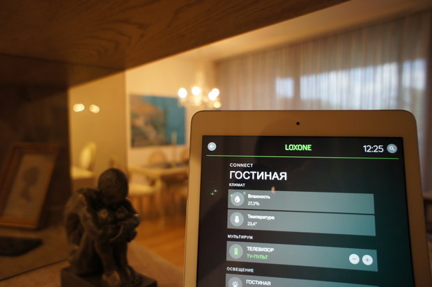 Интерьер гостиной в современном стиле с планшетом управления умным домом