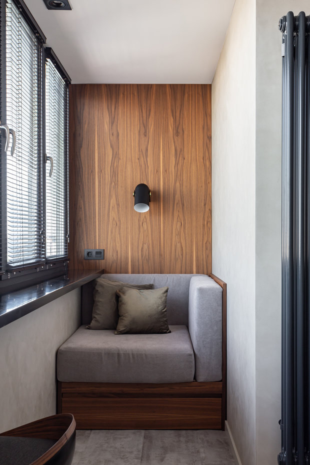 На балконе организовали зону отдыха и предусмотрели системы хранения.