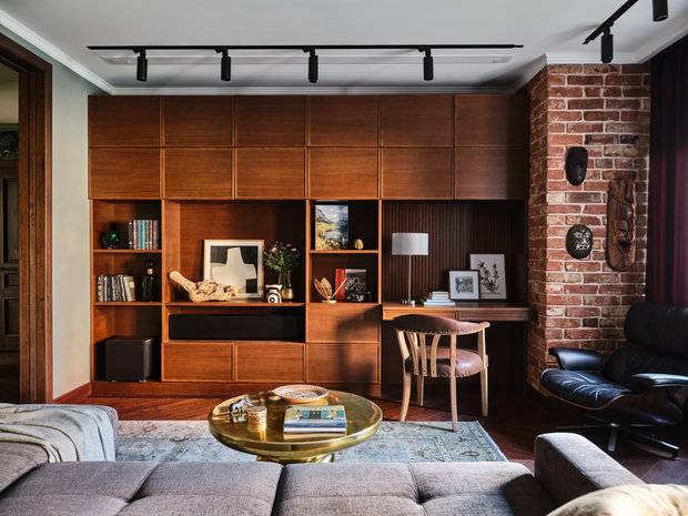 Кресло Eames 50-х годов, которое красуется теперь в гостиной, нашли на E-bay. Возле него на кирпичной стене разместили коллекцию африканских масок, привезенных из путешествий.