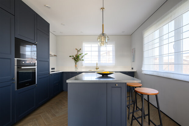 Для быстрых перекусов на кухне есть барная стойка, объединенная с островом. А для семейных посиделок — обеденный стол в гостиной. Раковина под окном была давней мечтой старшего поколения.