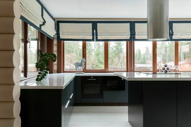 Кухня — П-образная, расположенная вдоль окон, очень вместительная. Из-за окон верхние шкафы не предусмотрены, но места для хранения много. Кроме того, есть кухонный остров, установленный в центре этой зоны. 