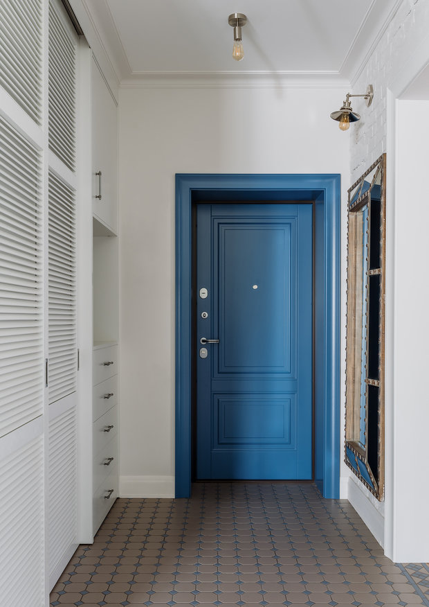 Цветная геометрическая плитка при входе и на кухне придает игривости интерьеру. Она также вдохновила выделить и сделать более яркой входную дверь.