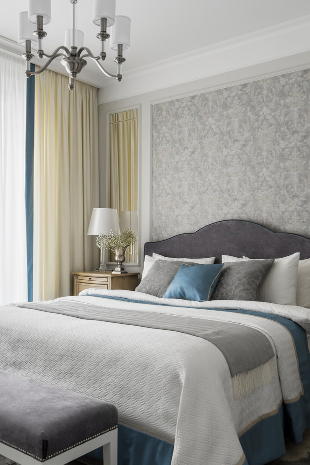 Стену в изголовье кровати украсили обоями в рамке из молдинга. Компаньонами стали все те же зеркала.