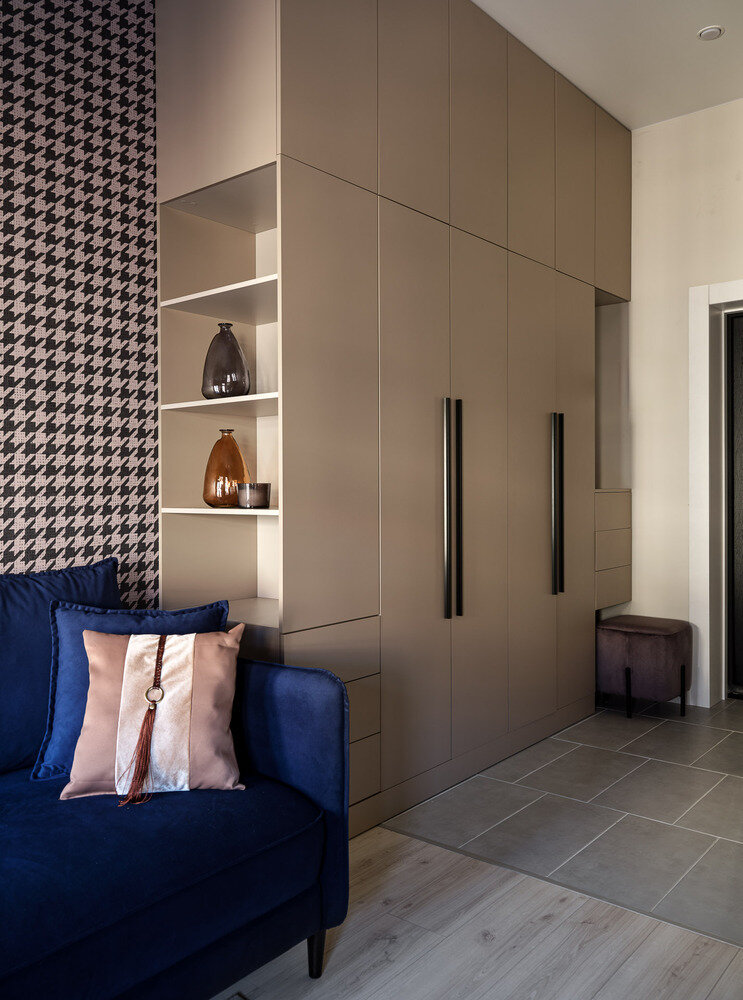 Модуль, выходящий в гостиную зону, двусторонний. Со стороны гостиной — открытые полки, со стороны прихожей — ящики. Все пространство до потолка занято антресольными шкафами. Модуль, выходящий в гостиную зону, двусторонний. Со стороны гостиной — открытые полки, со стороны прихожей — ящики. Все пространство до потолка занято антресольными шкафами.