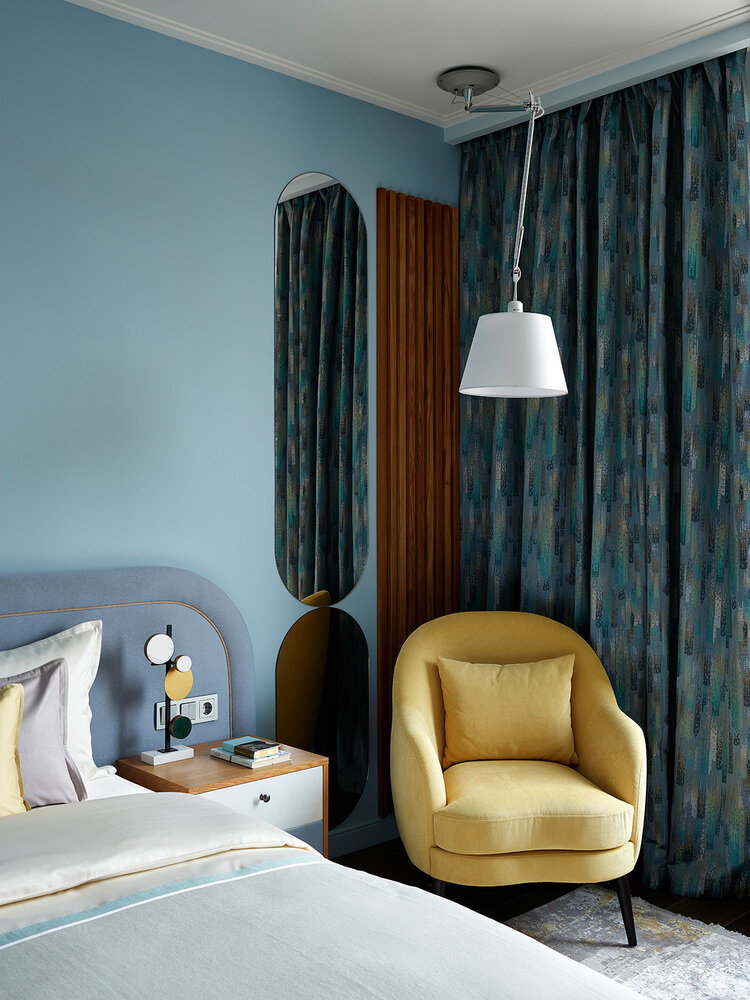 Зона чтения с креслом имеет свой регулируемый светильник, что очень удобно. Поскольку комната довольно большая, удалось организовать рабочее место, поставить вместительные тумбы, стеллаж и большой гардеробный шкаф.