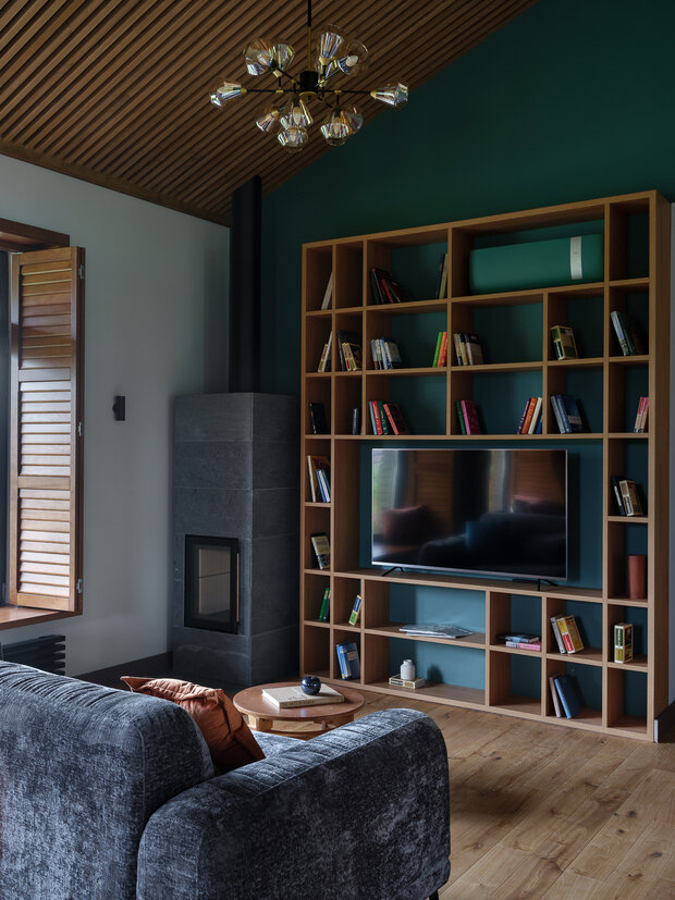 Яркая стена в зоне телевизора перекликается с цветом кухни.