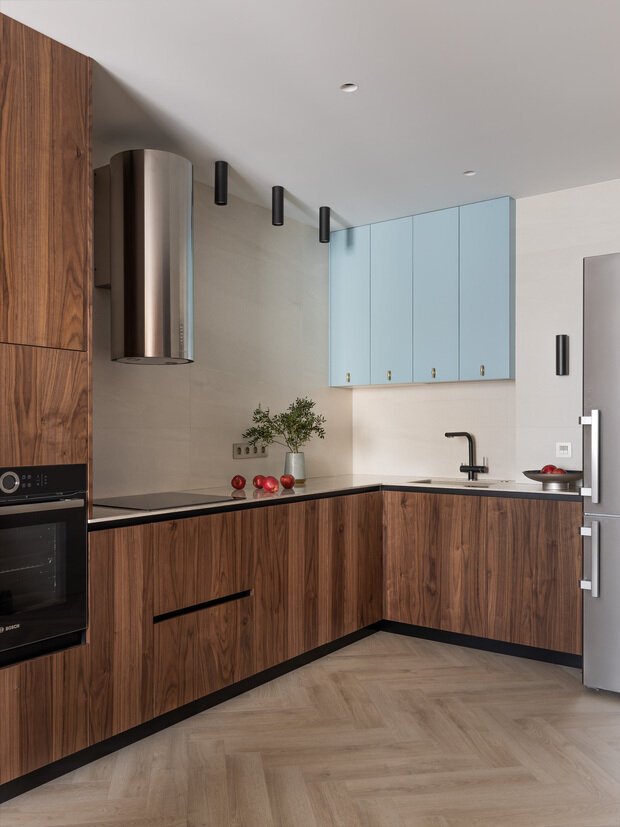 Интерьер кухни в стиле минимализм с деревянными фасадами и акцентными синими шкафами