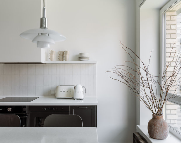 Светильникам как предмету дизайна уделено большое внимание в проекте. Акцентные точки визуального притяжения — подвесы над барной стойкой PH 3½-3 Поула Хеннингсена (Louis Poulsen), настенный светильник над столом 265 от компании Flos и бра возле кровати Lampe Gras 210 от DCW éditions.