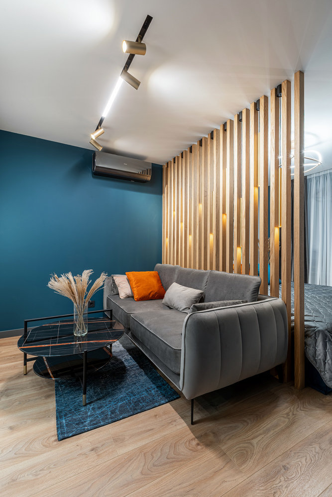 На полу в жилой зоне лежит ламинат, оттенок которого повторяет другую деревянную отделку.