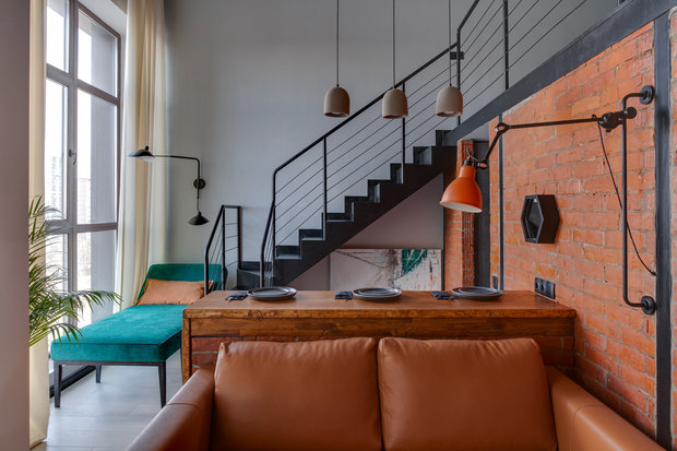 Около окна расположили зону отдыха с кушеткой и бра.