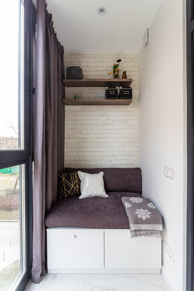 Одну стену на лоджии оформили декоративным кирпичом белого цвета.