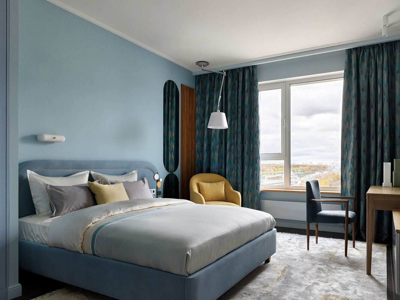 Кровать с мягким асимметричным изголовьем выполнена на заказ, продолжение изголовья вправо позволило необычно оформить зону с прикроватной тумбой.