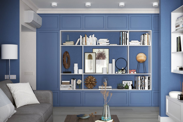Шкаф-стеллаж установили в проходной зоне гостиной. На синем фоне контрастными белыми линиями выделяются открытые полки с книгами и декором. 