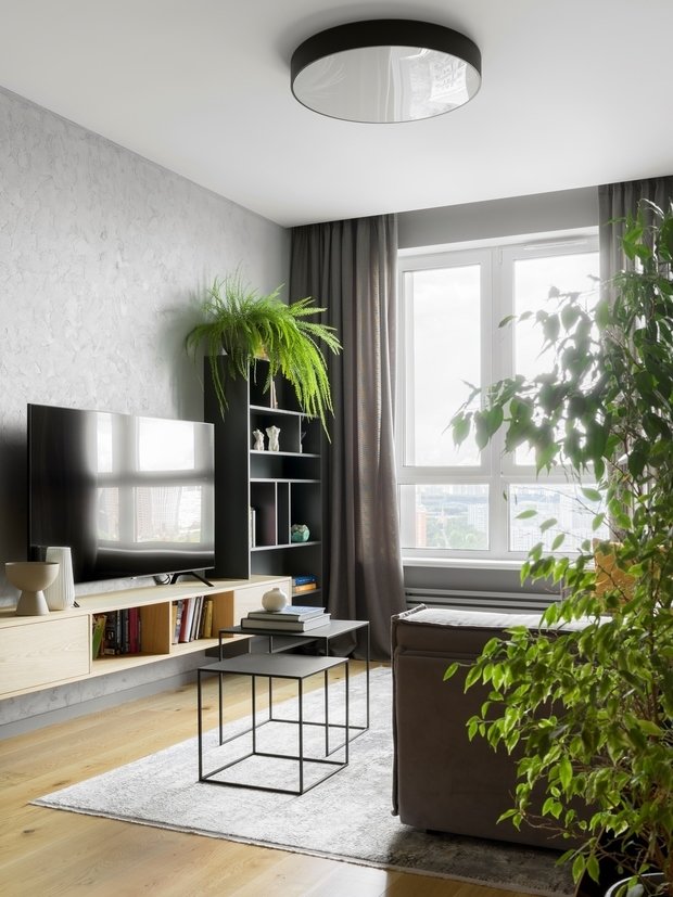 Большинство точечных предметов декора и освещения подобраны в черном цвете, что делает интерьер более фактурным и многогранным: в гостиной это бра Serge Mouille над диваном, журнальные столики H&M Home, светильники ИКЕА над островом. 