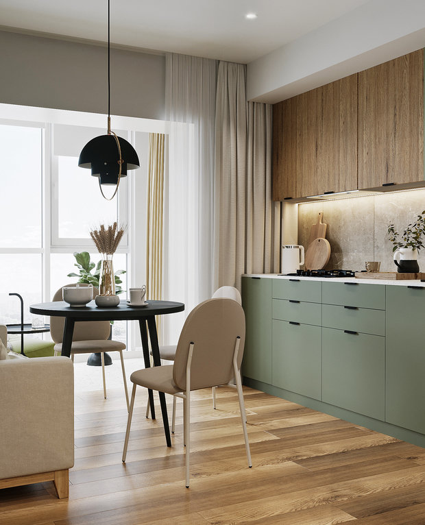 Так как кухня довольно компактная, дизайнеры выбрали для ее оформления преимущественно светлые оттенки — в первую очередь бежевый цвет, который дублируется также в прихожей и спальне, и сложный зеленый оттенок на стене за диваном и на кухонных фасадах.