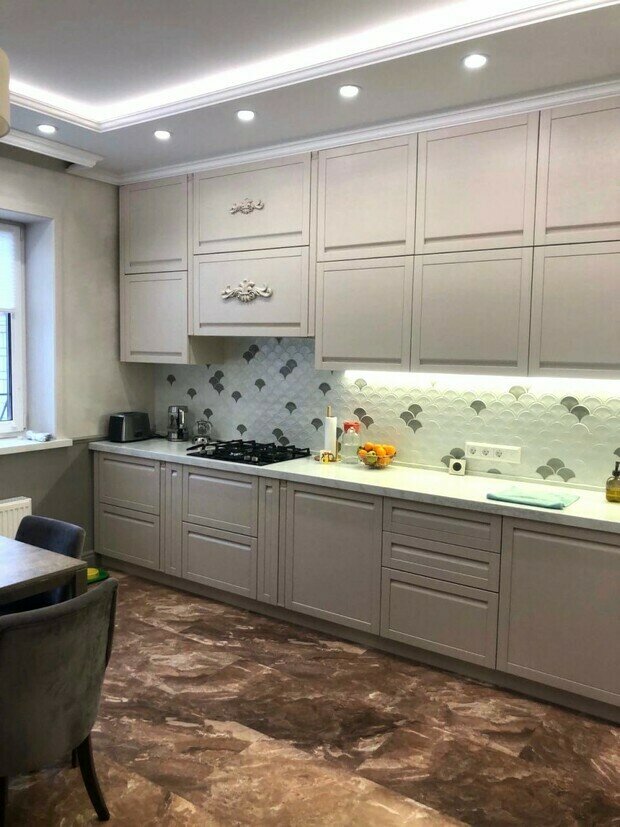 Интерьер кухни в современном стиле с серыми шкафами и мраморным полом