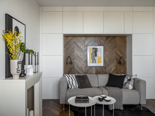 В гостиной система хранения сделана буквой П из шкафов ИКЕА. Диван в нише от фабрики BoConcept. У него есть электрический раздвижной механизм — реклайнер, он превращает диван по нажатию кнопки в шезлонг.