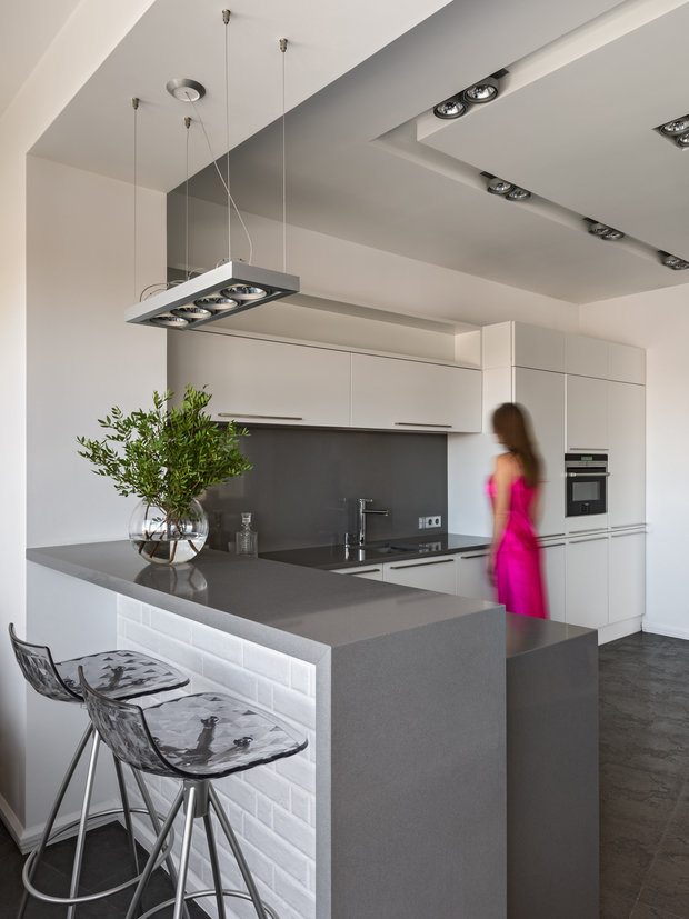 Кухня была сделана на заказ: вытяжка встраивается в столешницу, так она не перекрывает вид из окна. Вся техника встраиваемая, в квартире отопление автономное, поэтому котел спрятан в одной из колонн на кухне.