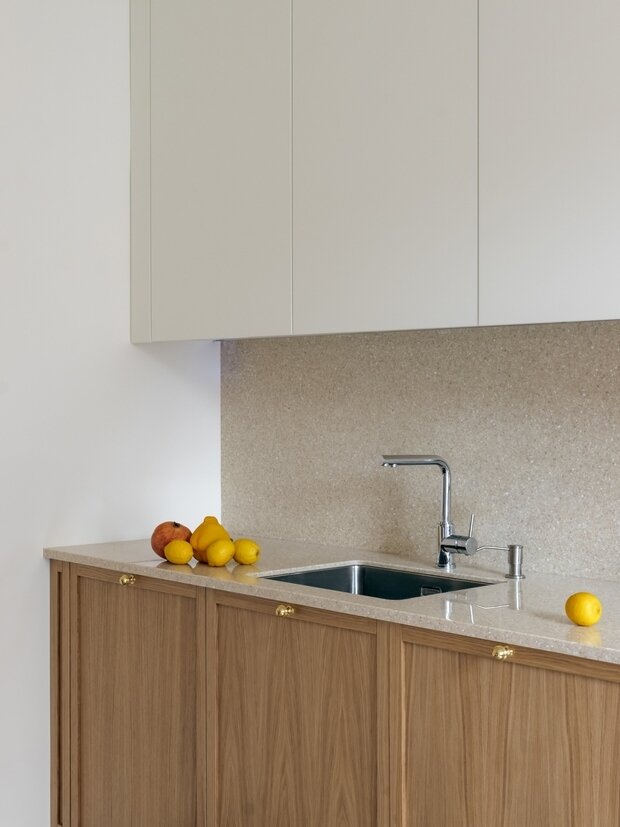 Для столешницы и кухонного фартука использовали искусственный камень, чтобы кухня смотрелась гармонично и лаконично.