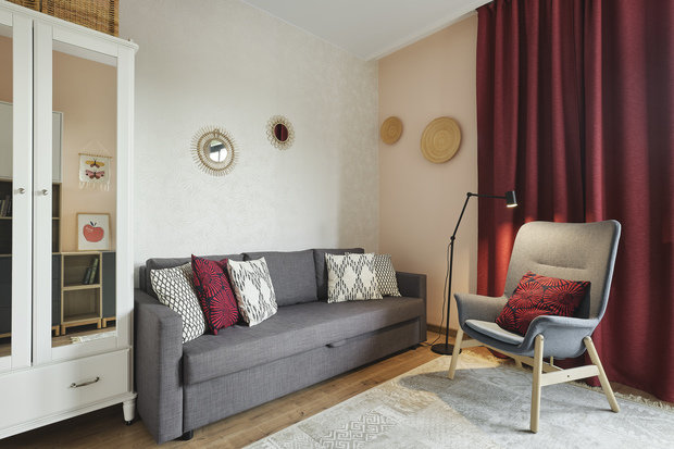 В гостевой комнате обои однотонные нежного персикового цвета, в изголовье дивана обои с легким растительным принтом, поддерживающим идею всей квартиры.