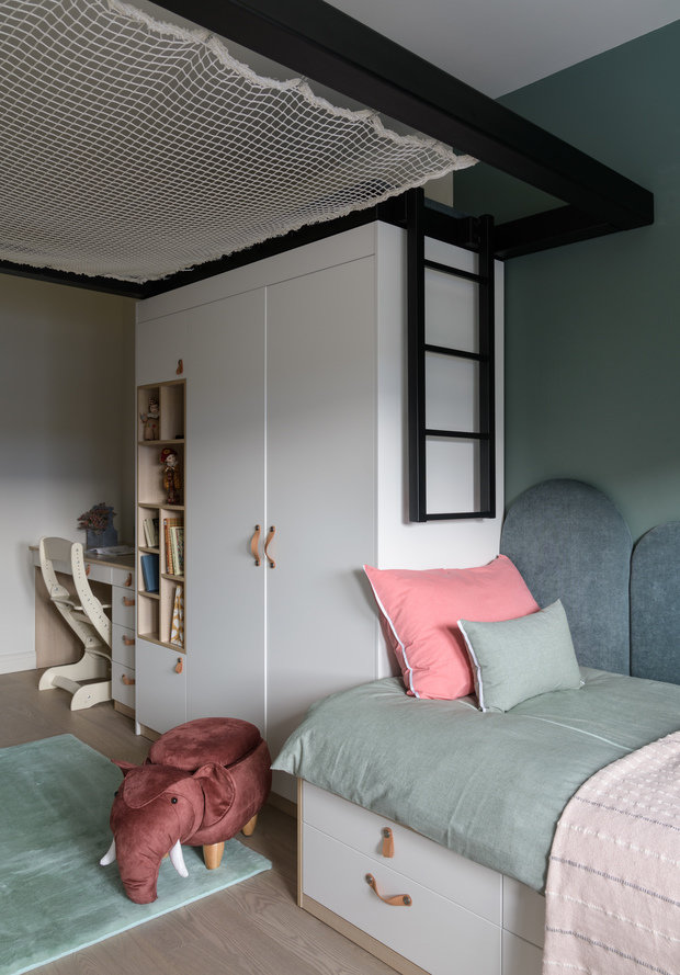 Особенность этой комнаты в организации спортивной зоны — игровой конструкции с сеткой, к несущим элементам которой могут крепиться качели, кольца и другое игровое оборудование.